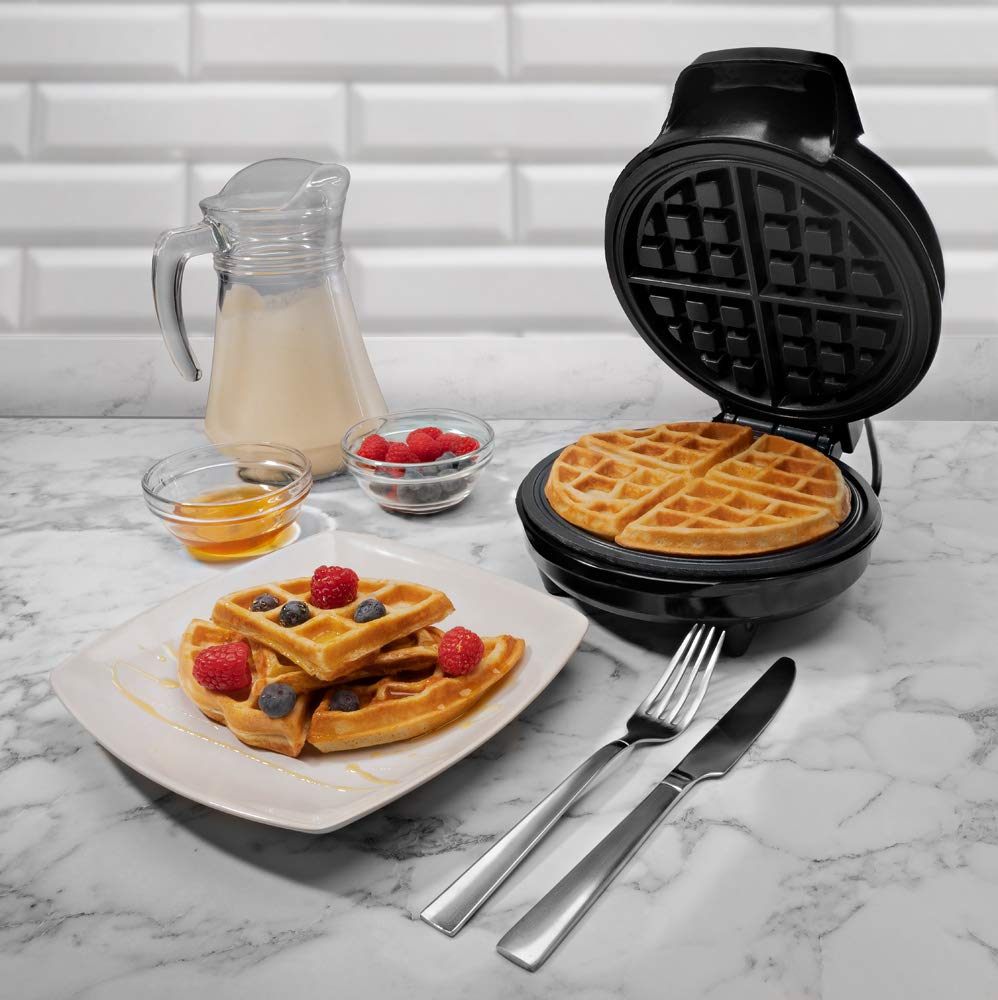 A modern waffle maker with non-stick plates, cooking golden-brown waffles on a kitchen counter.