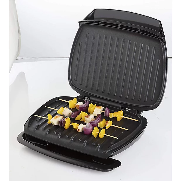 George Foreman Classic Grill with its iconic slanted grilling plates and a cooked chicken breast resting on top.