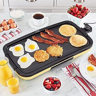 A variety of foods being cooked on an electric indoor grill and griddle.