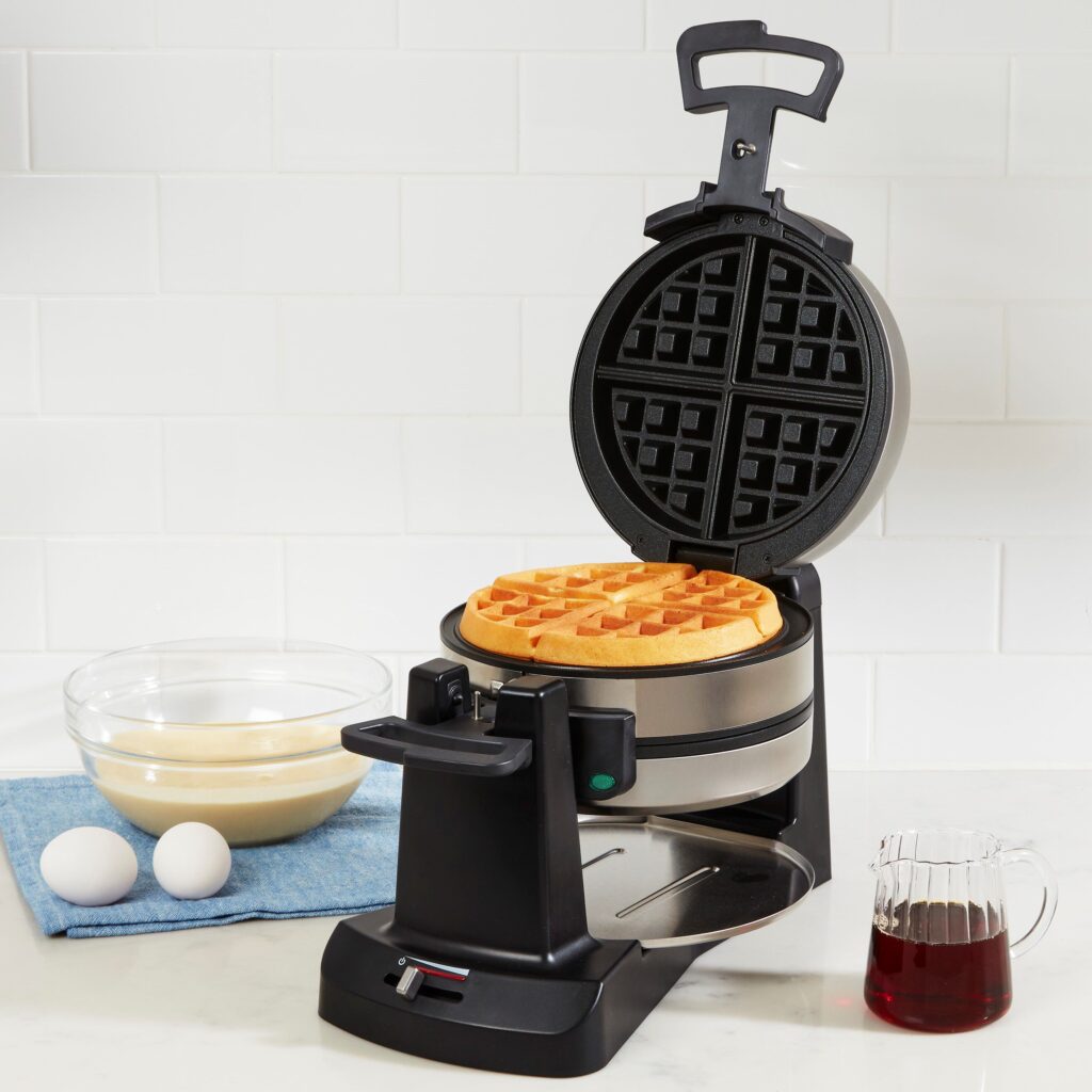 A Cuisinart Double Belgian Waffle Maker with two golden-brown waffles cooking side-by-side.