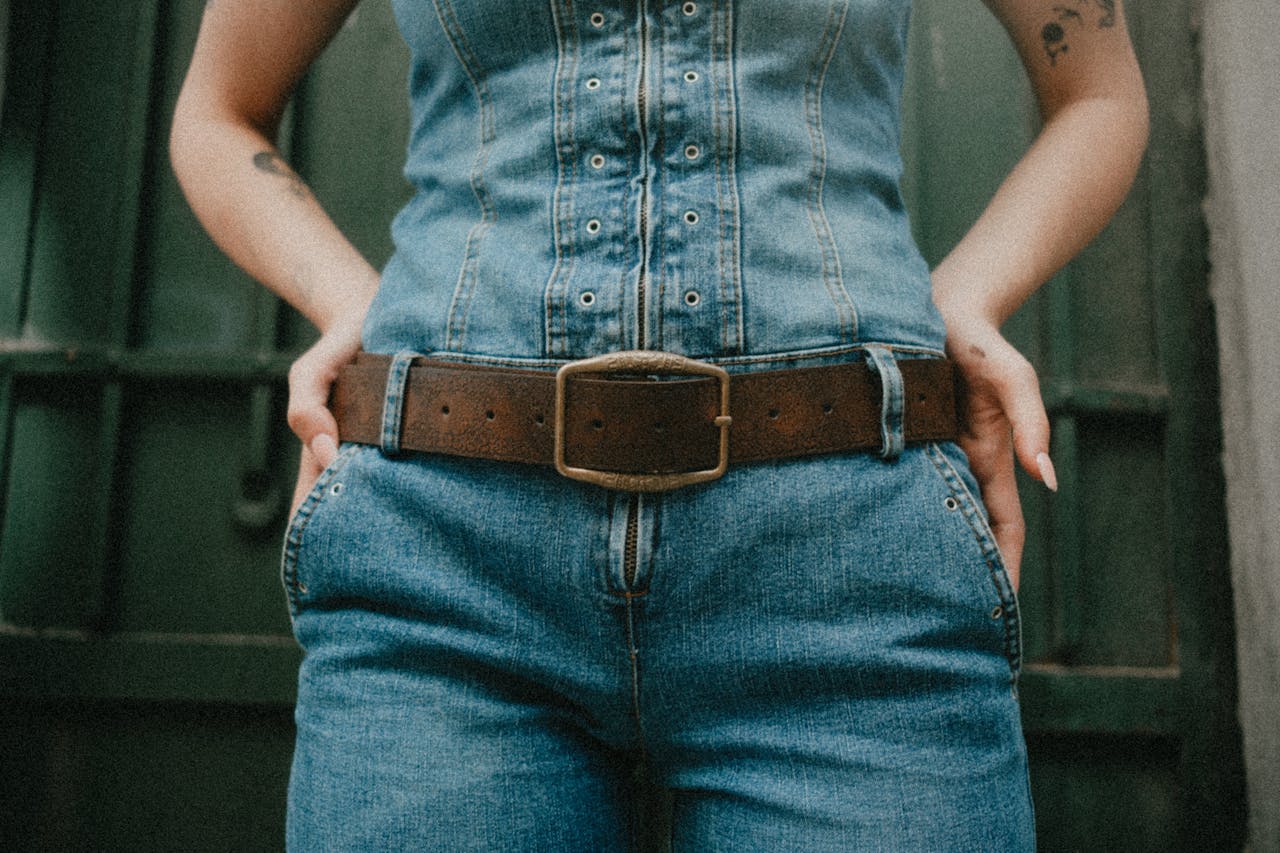 Close-up of woman wearing denim outfit with hands in pockets, showcasing fashion.
