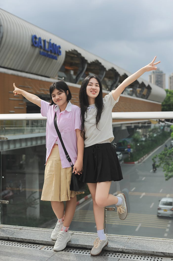 Two teenagers pose cheerfully in front of the GALAXY cinema in Hà Nội, Việt Nam, embodying vibrant street style.